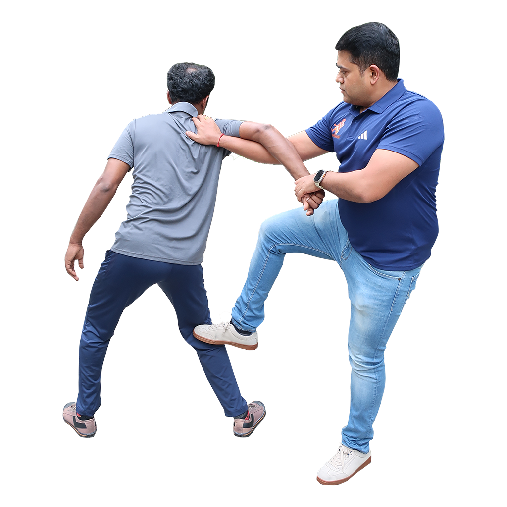 A martial artist demonstrating a Pidi Varmam hold in traditional attire, focused on balance and precision in a simple studio background.